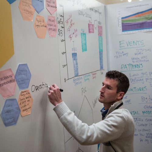 man writing on white board