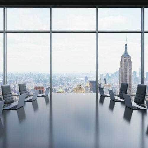 A conference room equipped by modern laptops in a modern panoramic office in New York.